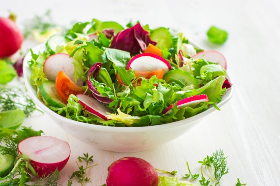 Healthy salad with fresh vegetables and ingredients on white background